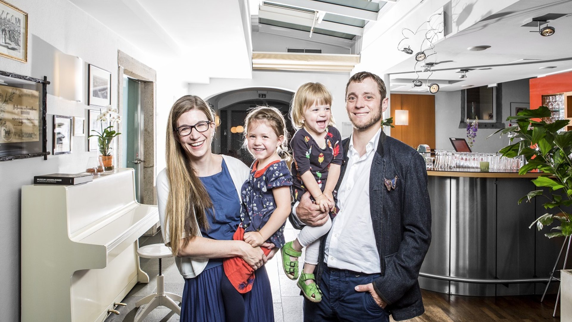 Foto: Fotostudio Eder Linz: Fotografie Julia Mühlberger, Bildbearbeitung Ella Kronberger: Familie Schick Boutique Hotel Hauser Hotelier Sophie Schick mit ihrem Lebensgefährten und beiden kleinen Töchtern in der Hotellobby.